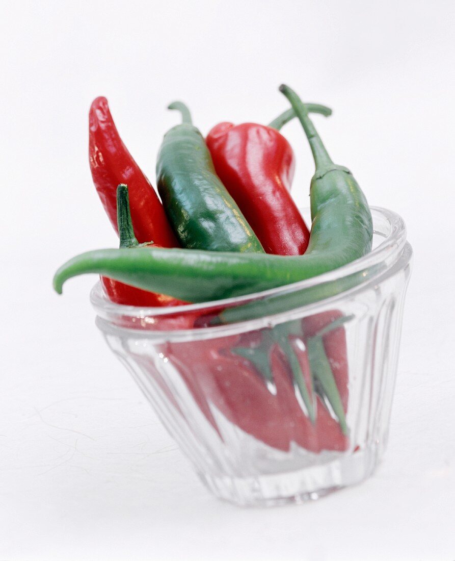 Red and green chilis in glass tumbler