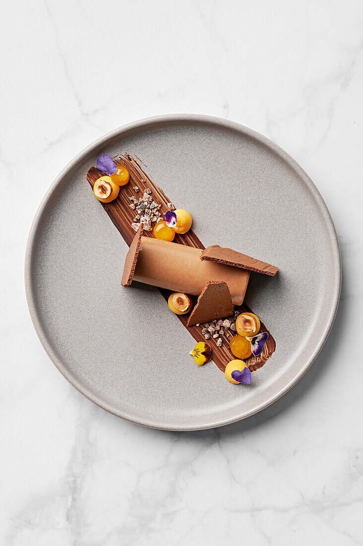 Chocolate mousse, passion fruit quark, candied hazelnuts, cocoa nib praline, passion fruit gel, dried chocolate