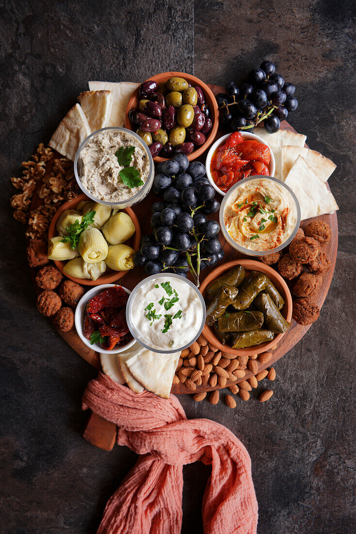 Mediterranean diet charcuterie board grazing platter on dark slate background.