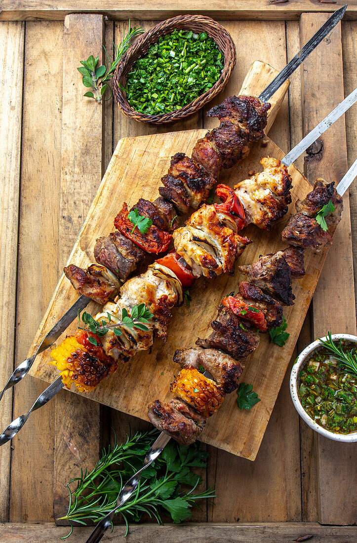 Bbq meat on wooden skewers on plate. Top view, flat lay.
