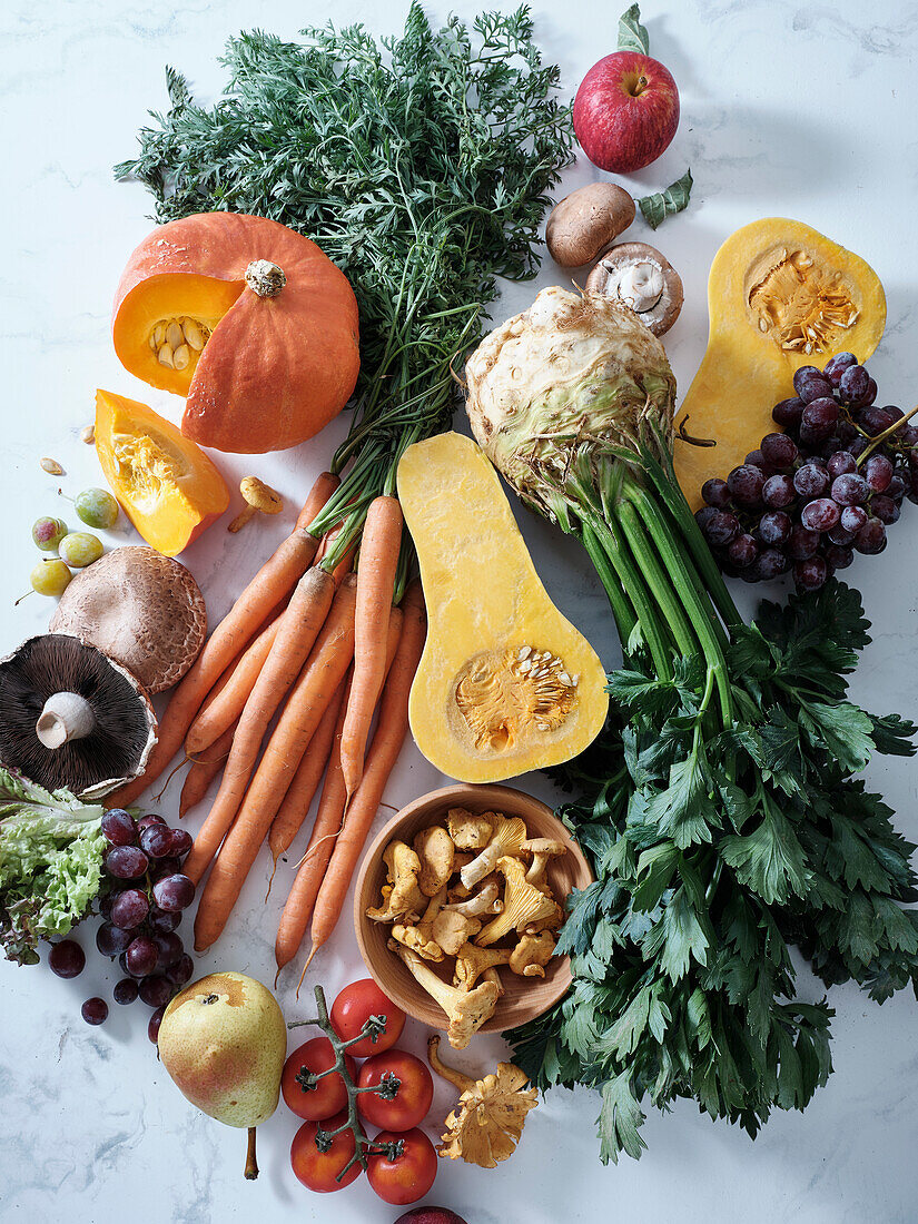 Healthy seasonal vegetarian food. Flat plate with autumn vegetables, fruit and mushrooms from the local market. Vegan ingredients