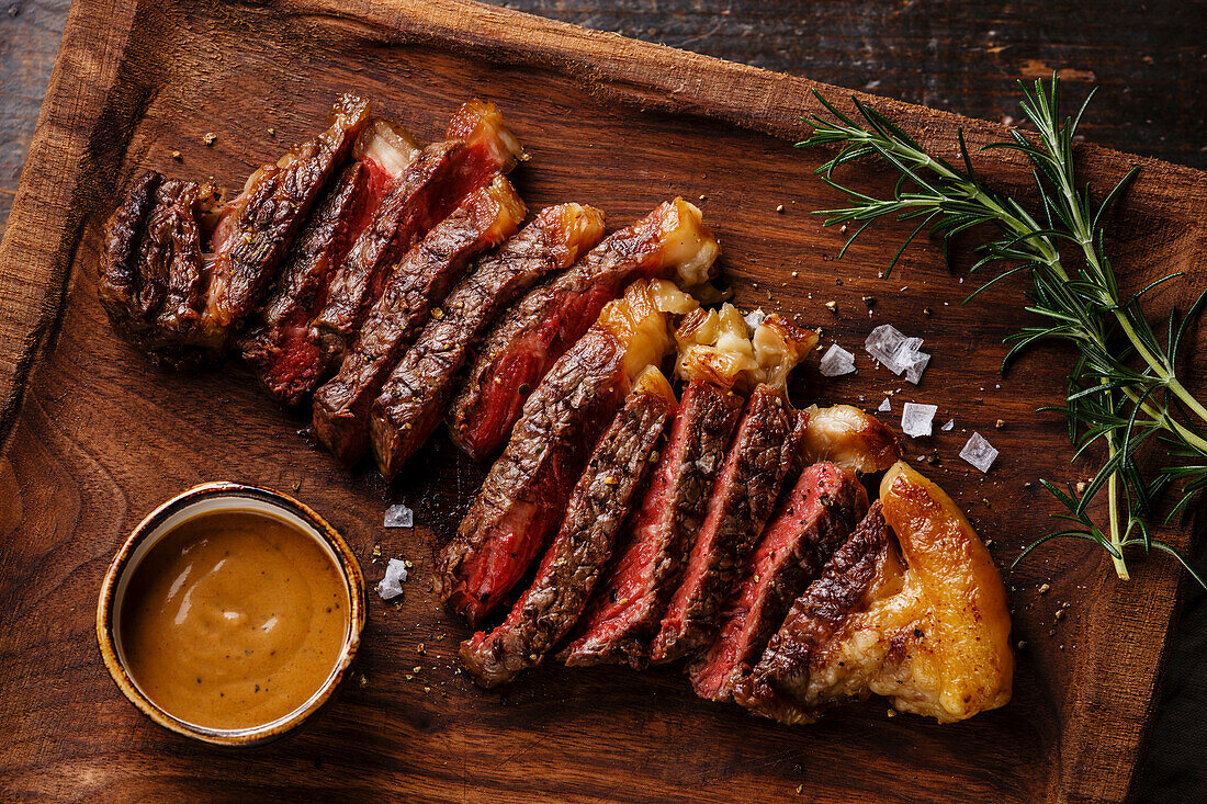 Grilled sliced Steak Striploin with Pepper sauce close-up