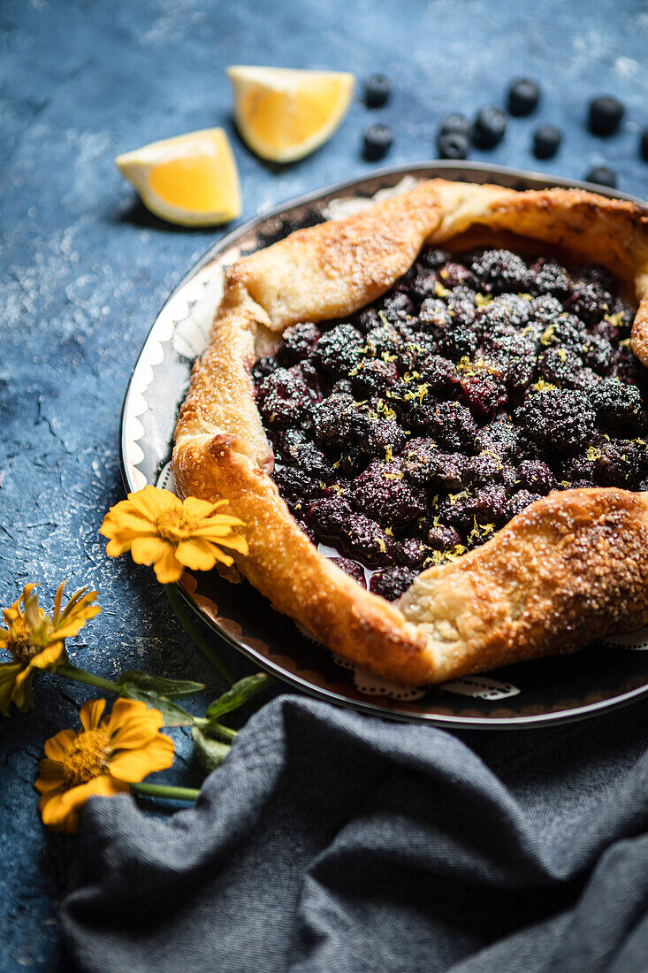 Blueberry and blackberry galette on a blue background