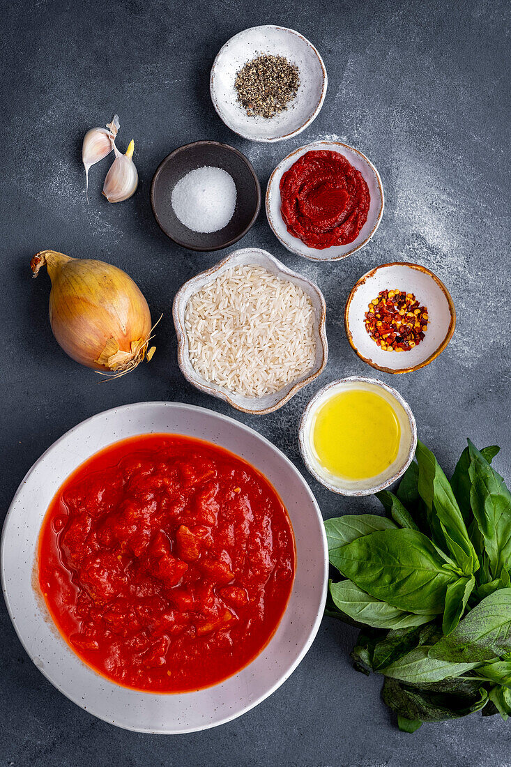 Ingredients for tomato soup photographed on a grey background