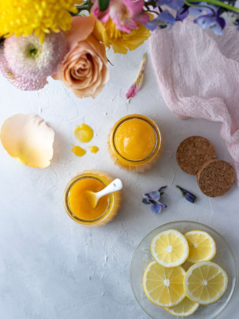 Zitronenquark in Gläsern, dekoriert mit Frühlingsblumen und Pastellfarben
