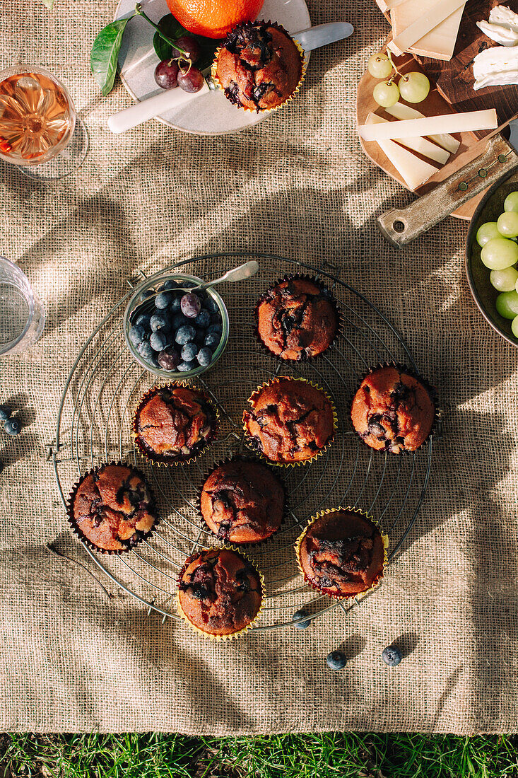 Flatlay of a tray of blueberry muffins as part of a picnic scene