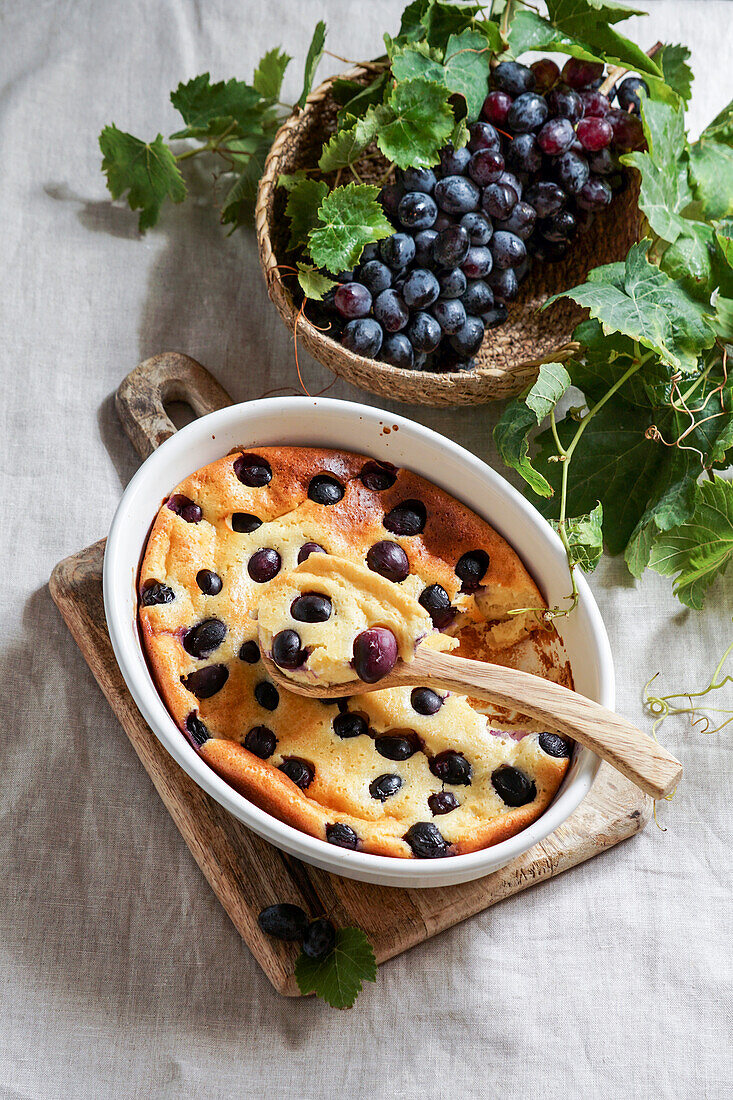 Red grape clafoutis, French cuisine. on a ceramic tile table with a blue pattern