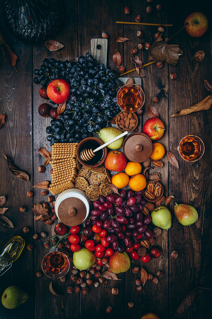 Vegan cheese platter with fresh fruit and savoury pastries on a wooden table