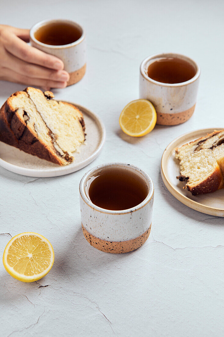 Schwarzer Tee mit Zitrone in kleinen Keramikbechern