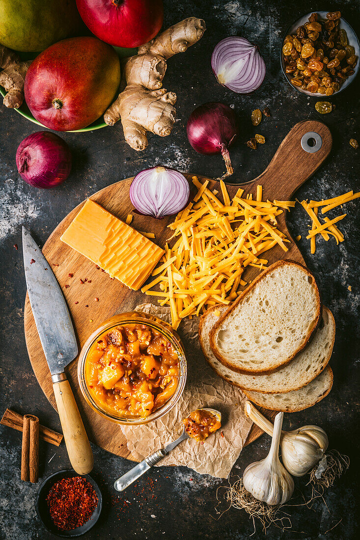 Rustic board with grated cheese, bread, mango chutney and ingredients