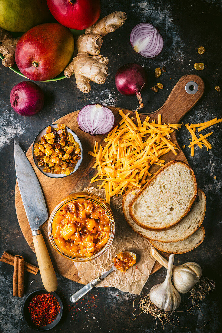 Rustic board with grated cheese, bread mango chutney and sultanas
