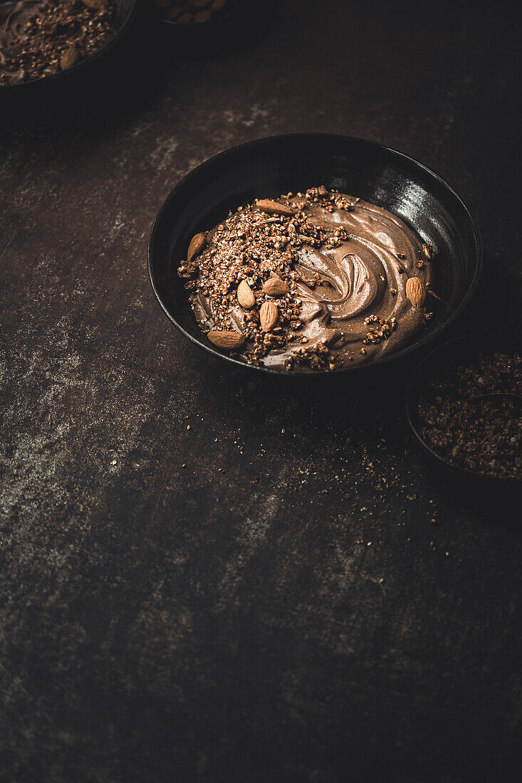Vegan chocolate smoothie bowl with copy template against a dark background