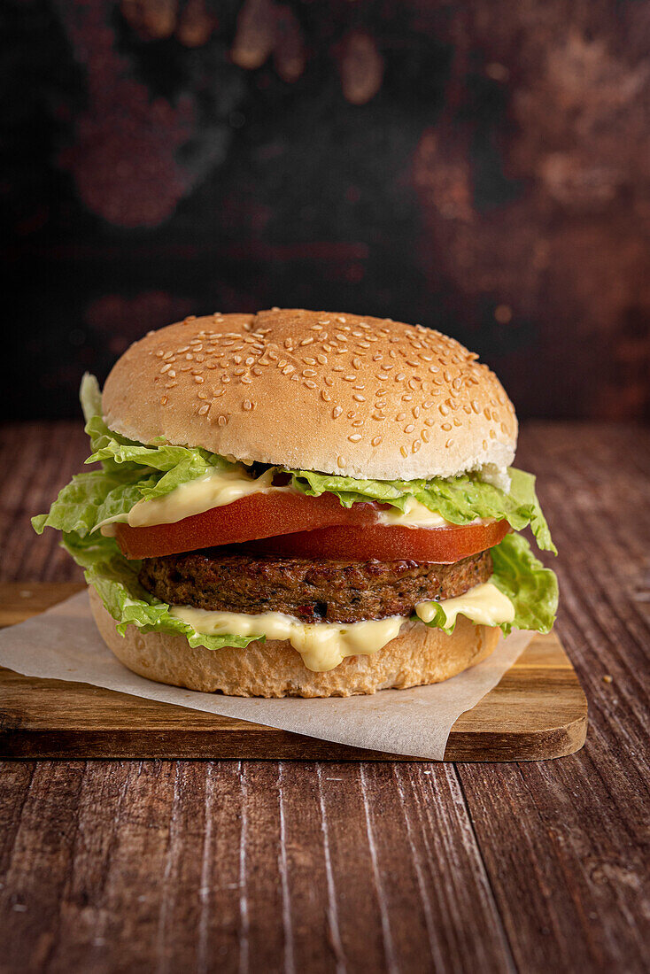 Veganer Burger mit Gemüsepatty auf einem Holzuntergrund
