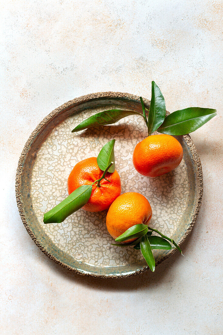 Three satsumas on one plate