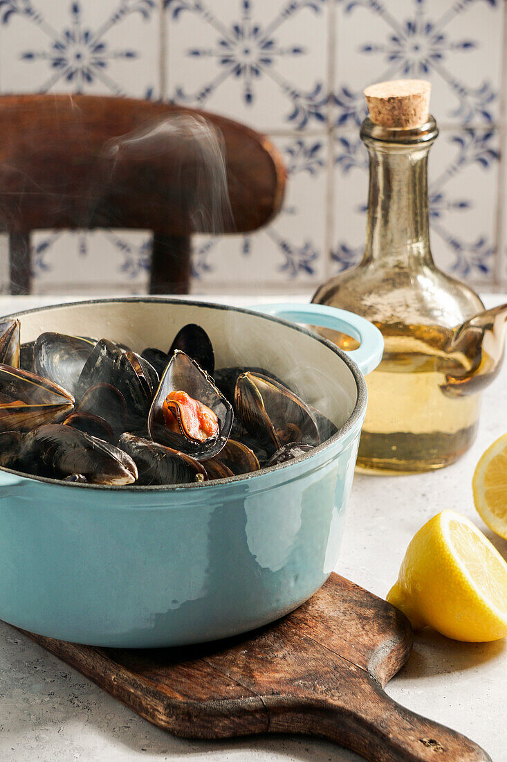 Mussels in white wine and lemon juice in a blue cast-iron casserole dish