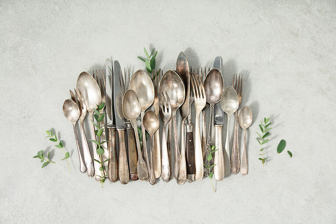 Rustic vintage cutlery on grey stone background flat lay from above