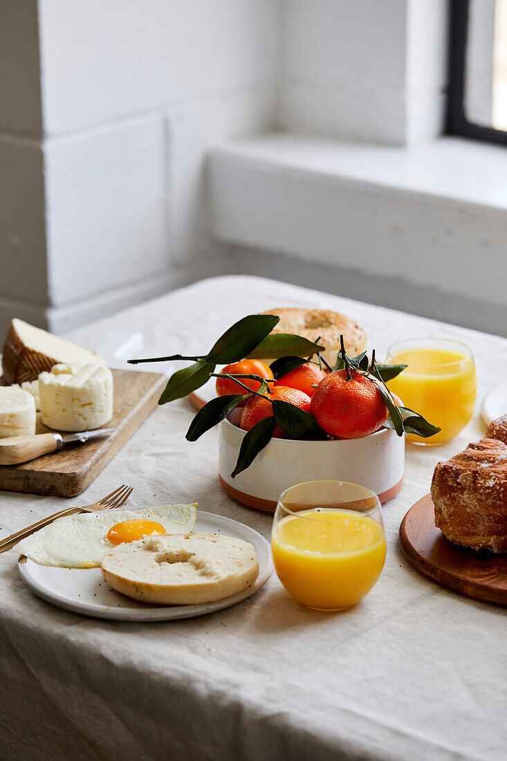 Breakfast tablescape with pastries, orange juice and fruit