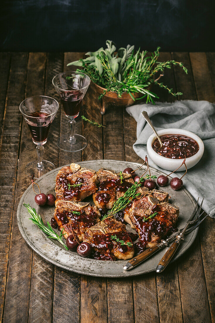 Lamb chops on a pewter plate, with cherry and port sauce and port glasses