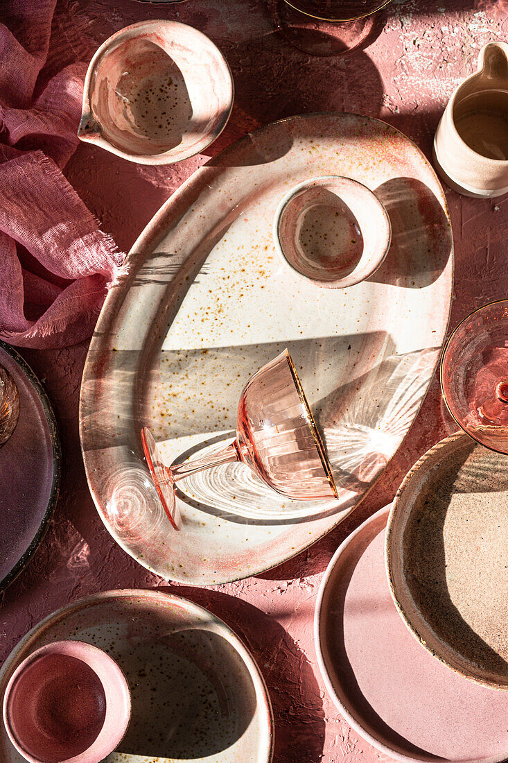 A margarita glass on a pink background with crockery