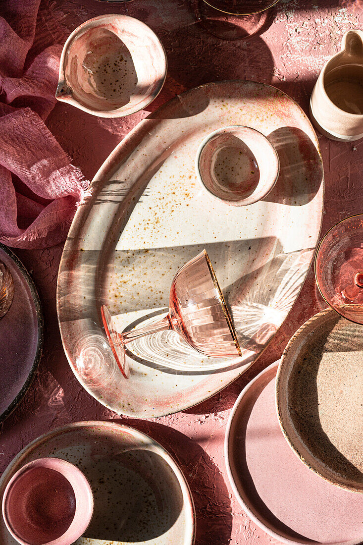 Ein Margarita-Glas auf rosa Hintergrund mit Geschirr