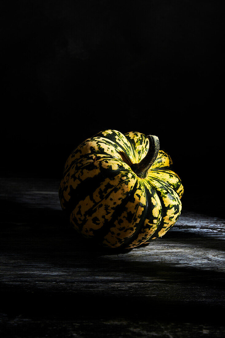 Pumpkin portrait on dark surface and background