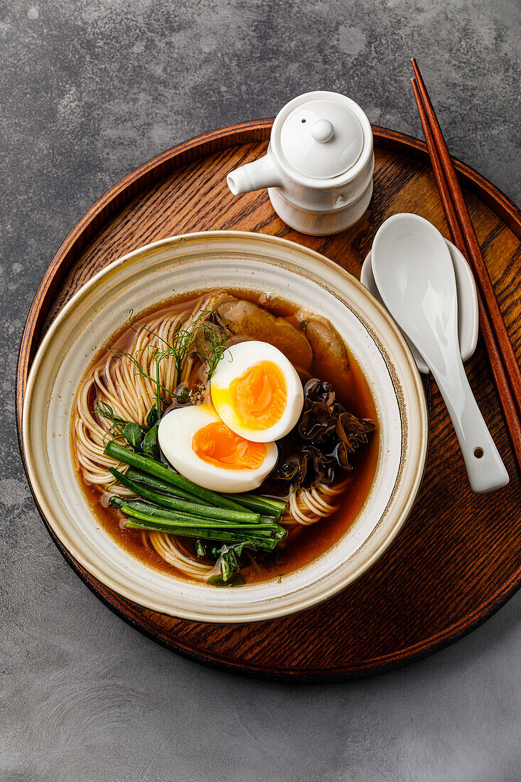 Ramen, Asian noodles in broth with beef tongue, mushrooms and eggs in a bowl