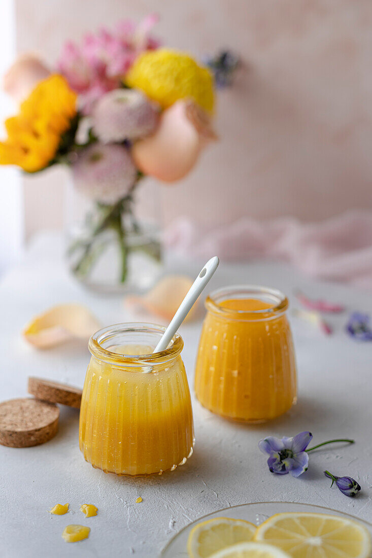 Lemon curd in jars, decorated with spring flowers and pastel colours