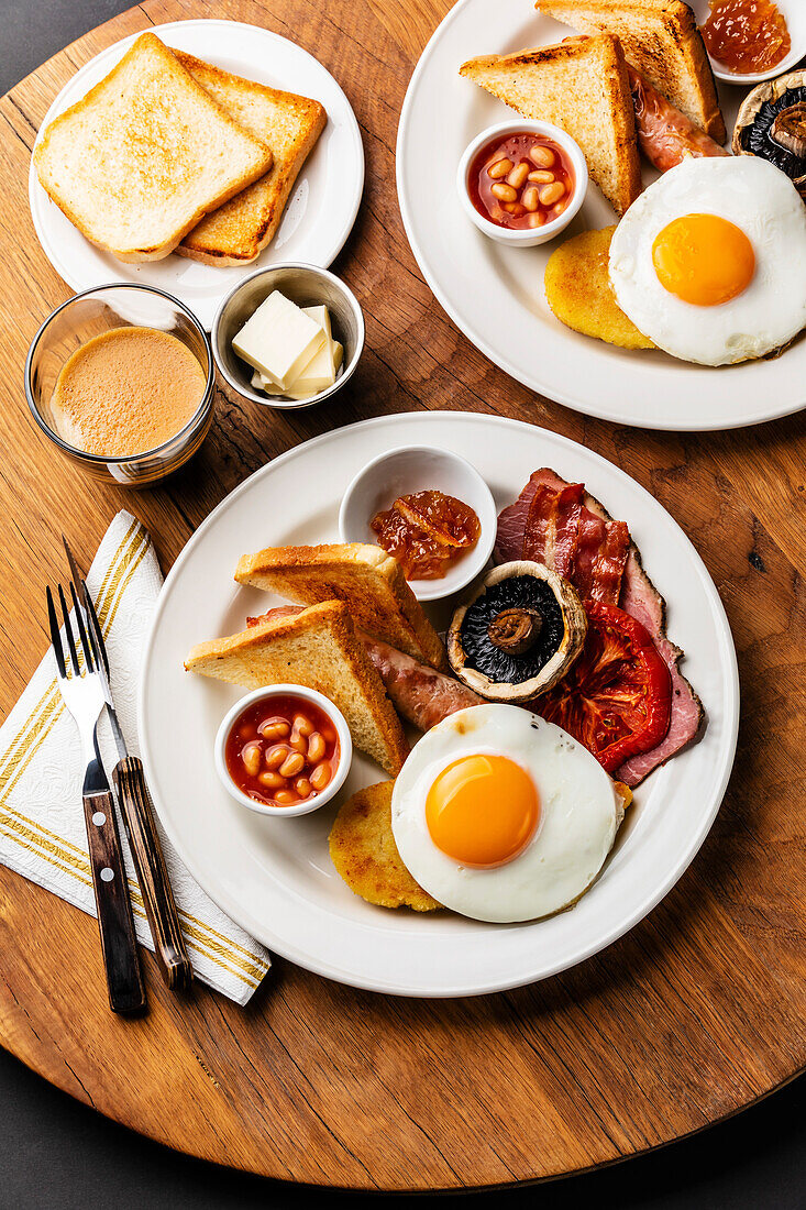 Komplettes englisches Frühstück mit Spiegeleiern, Würstchen, Speck, Bohnen und Toast