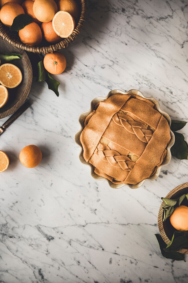 Orangenkuchen mit dekorativem Blätterteig auf einer Marmorküchenoberfläche