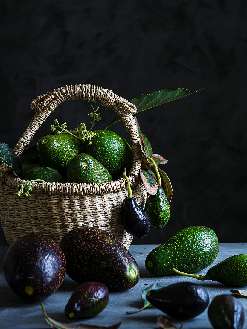 Black and green avocados in a basket