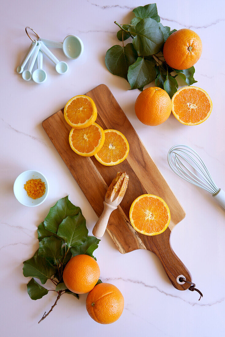 Kochen und Backen mit Orangen Lebensmittelzubereitung auf weißem Marmor Hintergrund. Flatlay von oben nach unten
