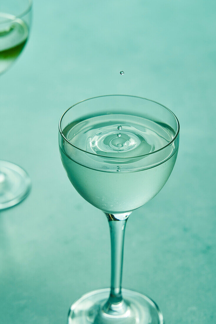 Dry martini with lime on a sage green background