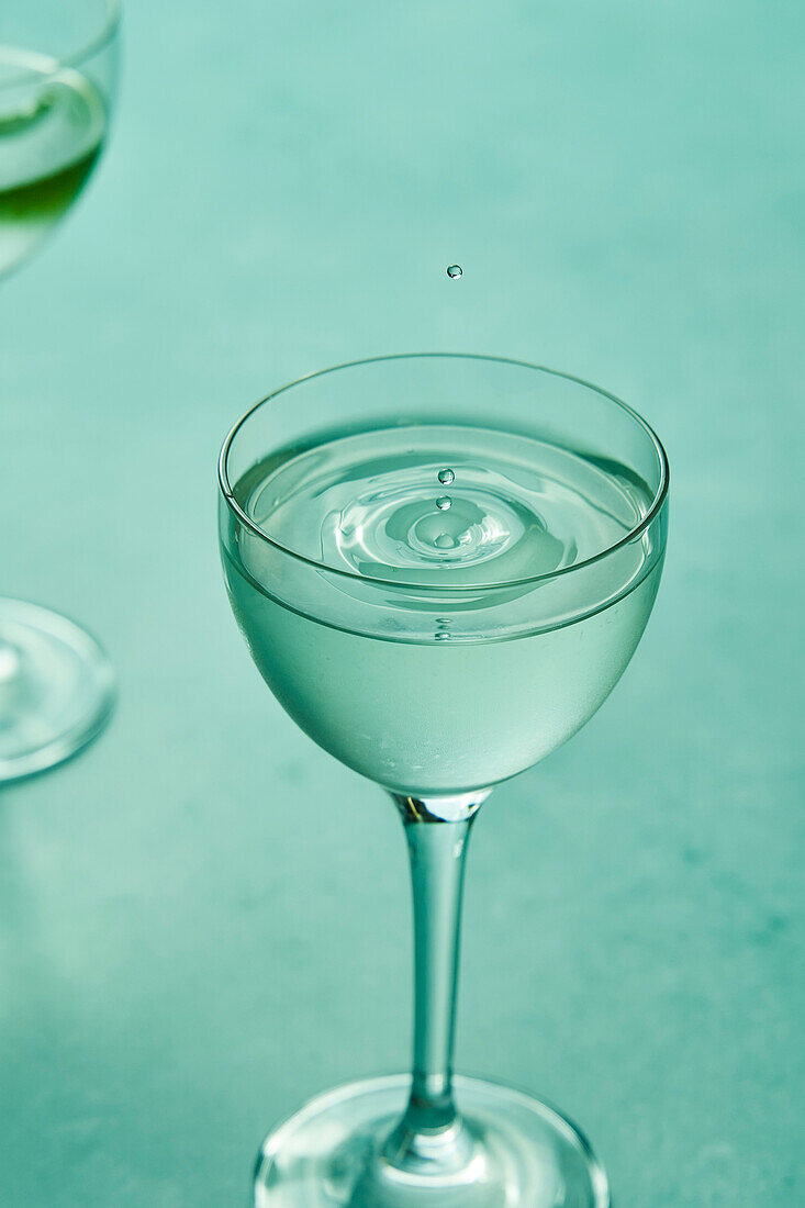 Trockener Martini mit Limette auf salbeigrünem Hintergrund