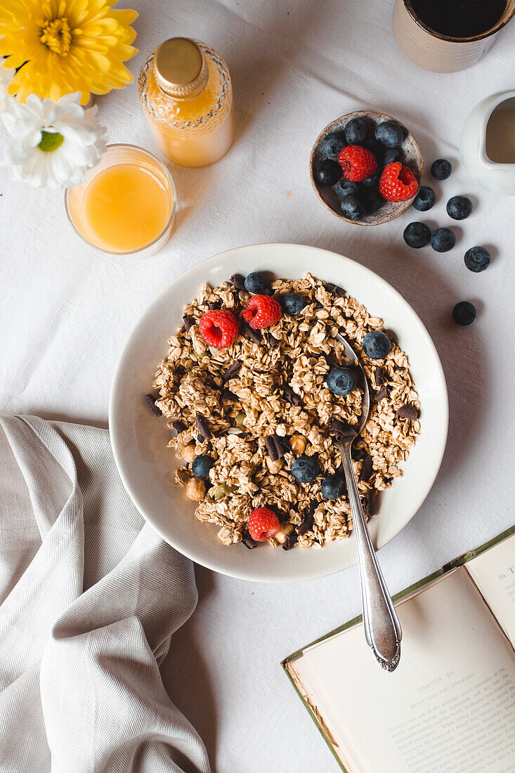 Flatlay of a breakfast scene with muesli, juice and fresh berries