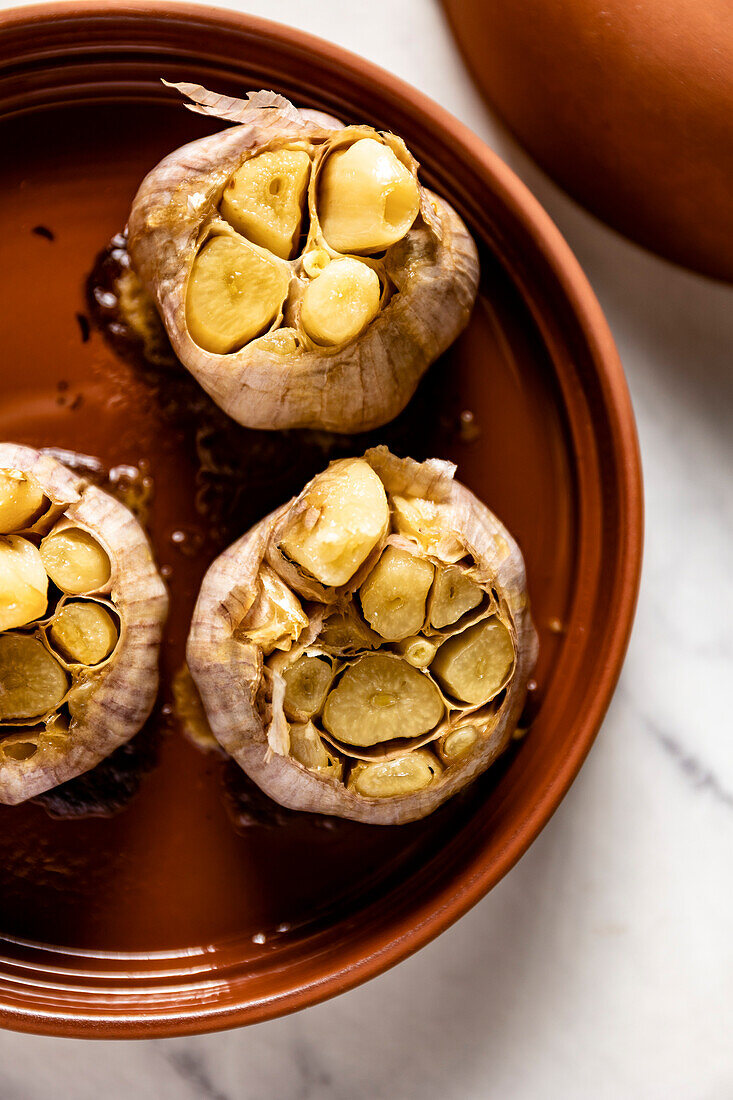 Home-baked garlic cloves on a baking tray