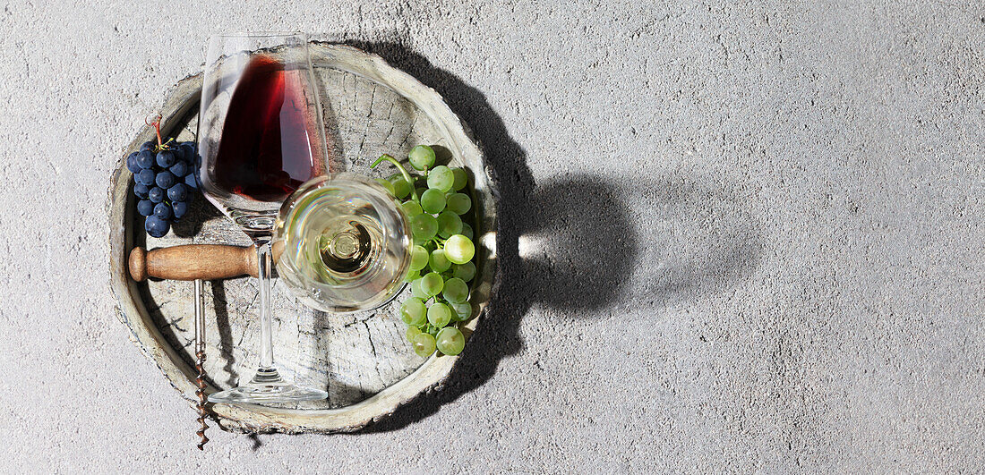 Wine composition with beautiful sunlight and shadows on a grey background. Top view, laid flat. Wine bar, winery, wine tasting concept. Minimalistic trendy photography