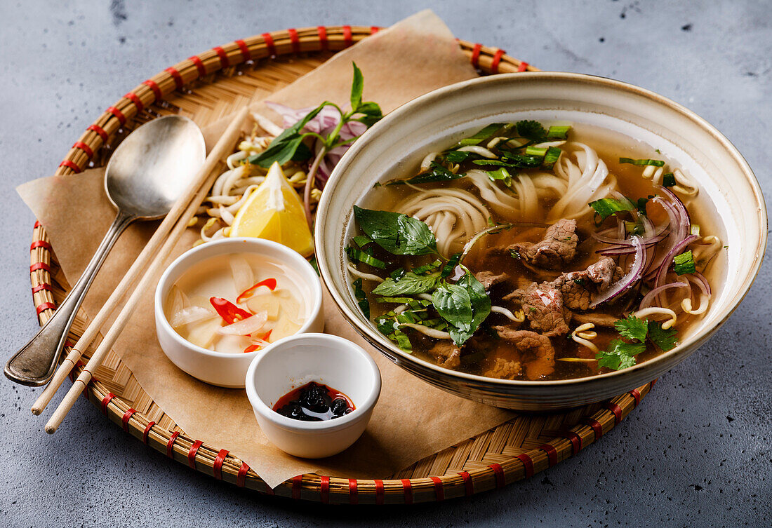 Pho Bo vietnamese Soup with beef in tray on concrete background