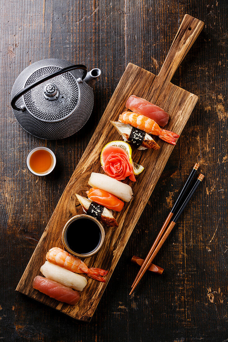Nigiri-Sushi-Set auf Holzbrett und grünem Tee