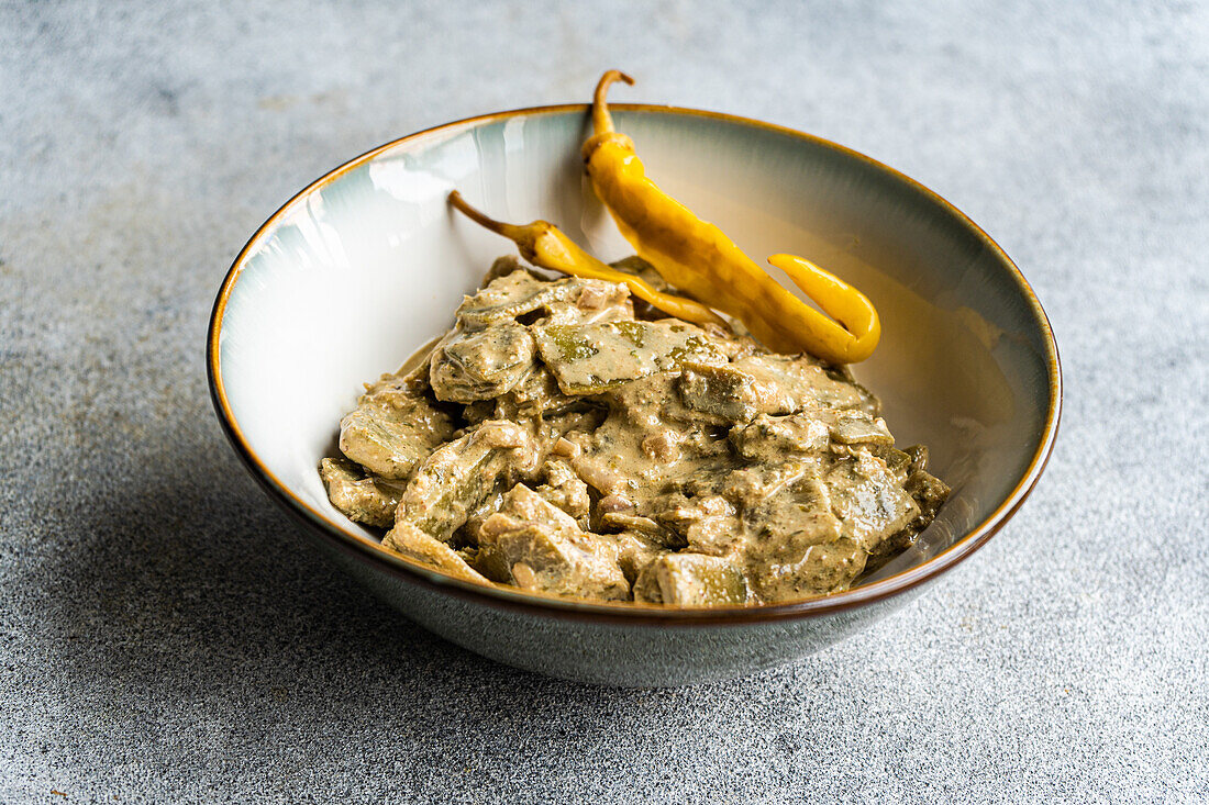 Front view of a plate of Georgian green beans with walnut sauce against a light-coloured background