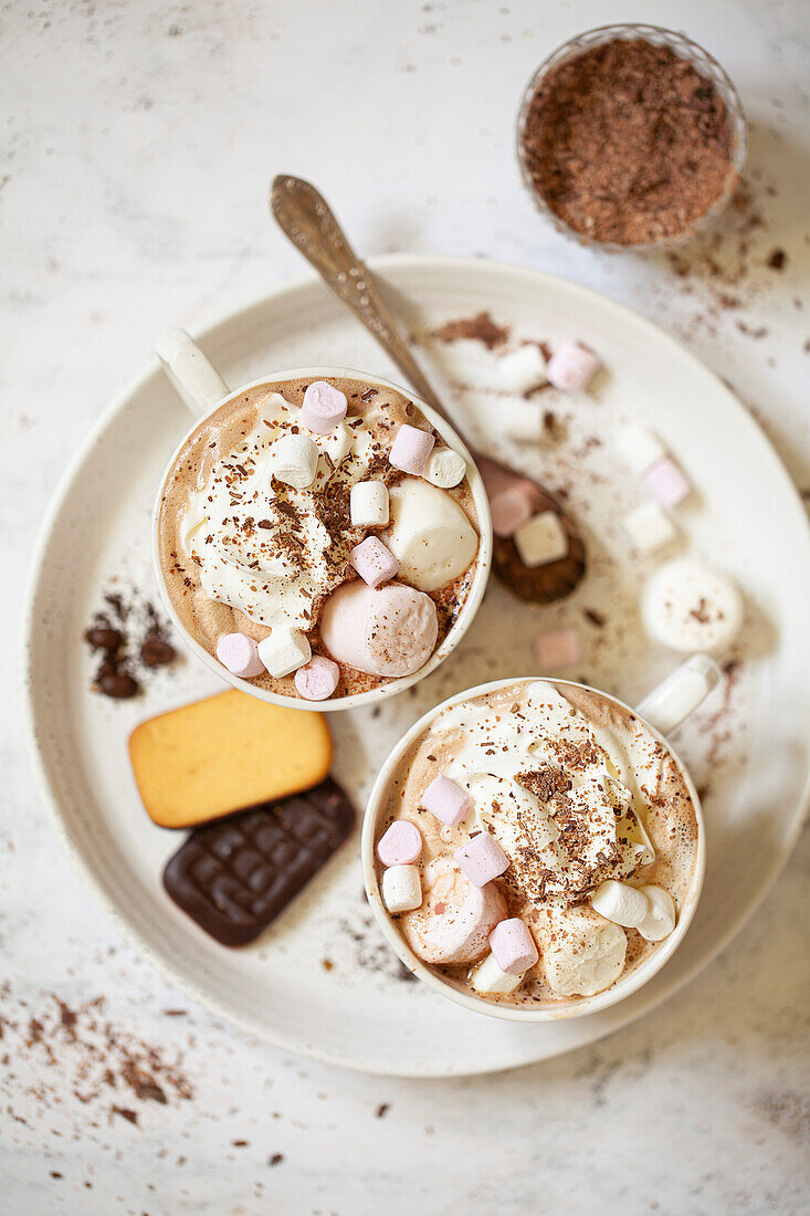 Zwei Becher Irish Cream Mocha Latte mit Schlagsahne, geriebener Schokolade und Marshmallows