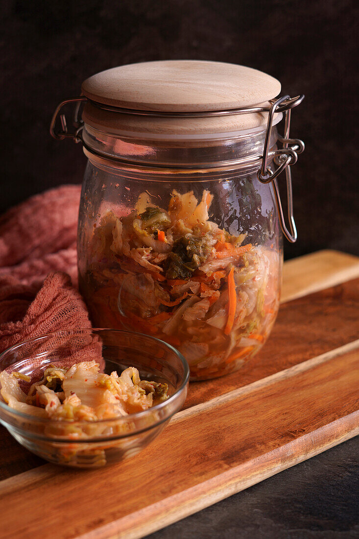 Gesundes probiotisches Kimchi nach koreanischer Art in einem Glasgefäß, Nahaufnahme vor einem dunklen Hintergrund