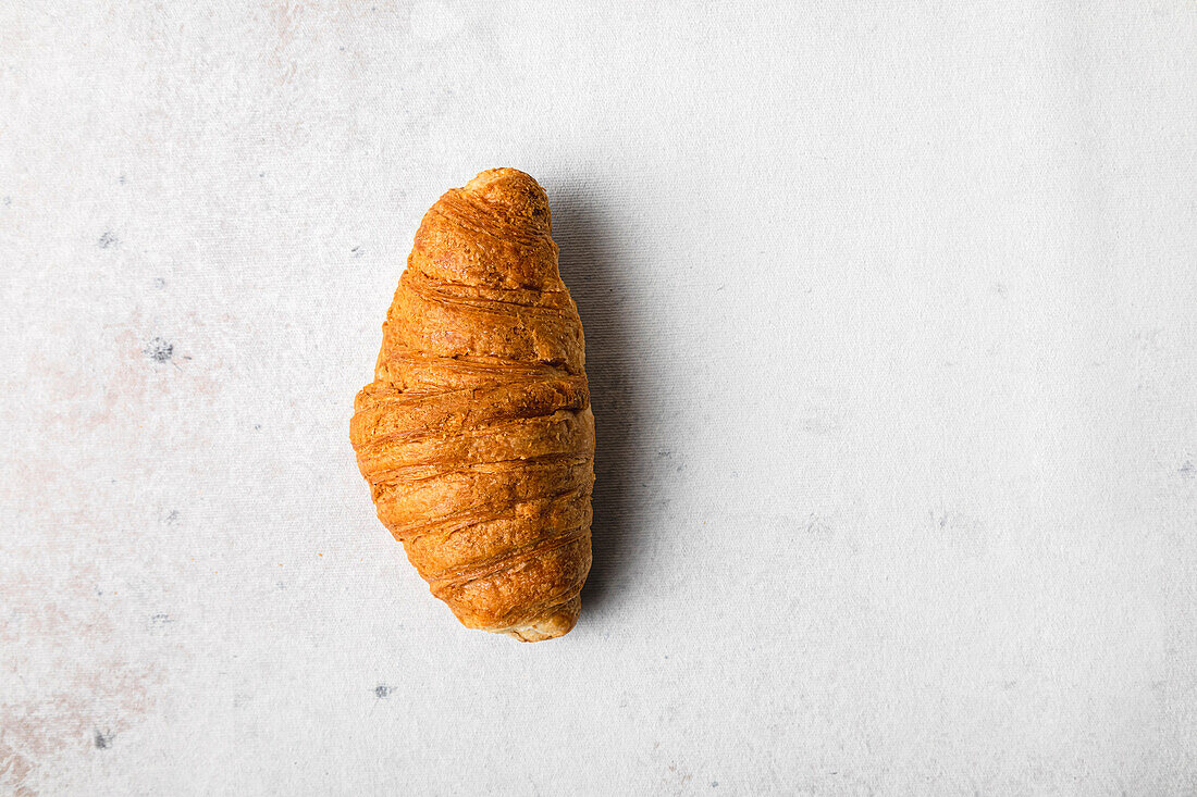 Einzelnes Croissant auf weißem Hintergrund