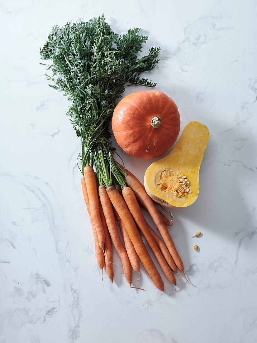 Draufsicht mit herbstlich-orangem Gemüse. Karotten, Kürbis, Butternusskürbis