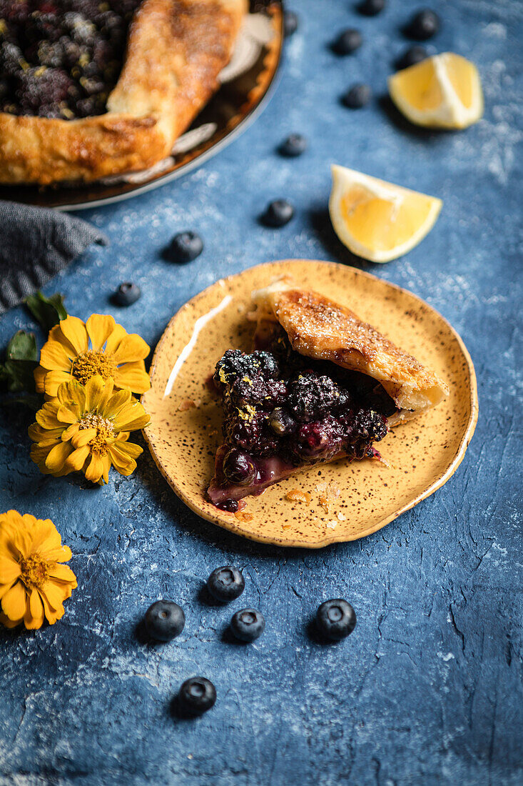 Heidelbeer- und Brombeergalette auf blauem Hintergrund