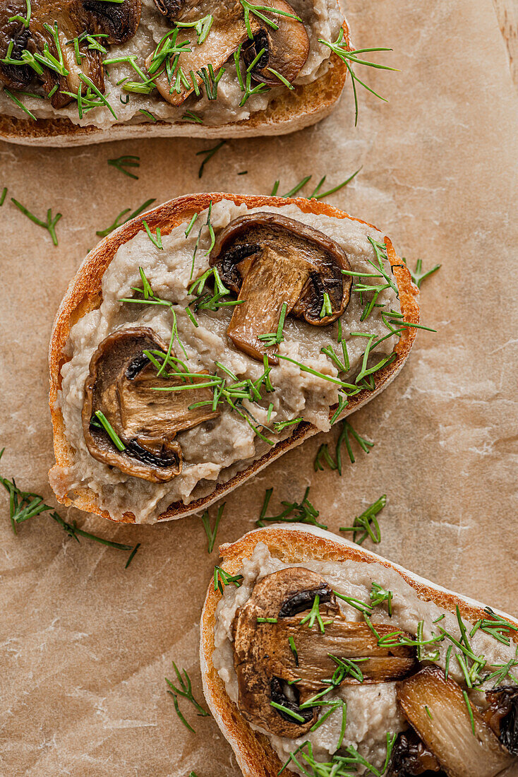 Sandwiches mit Pilzpastete und Champignons auf Kraftpapier