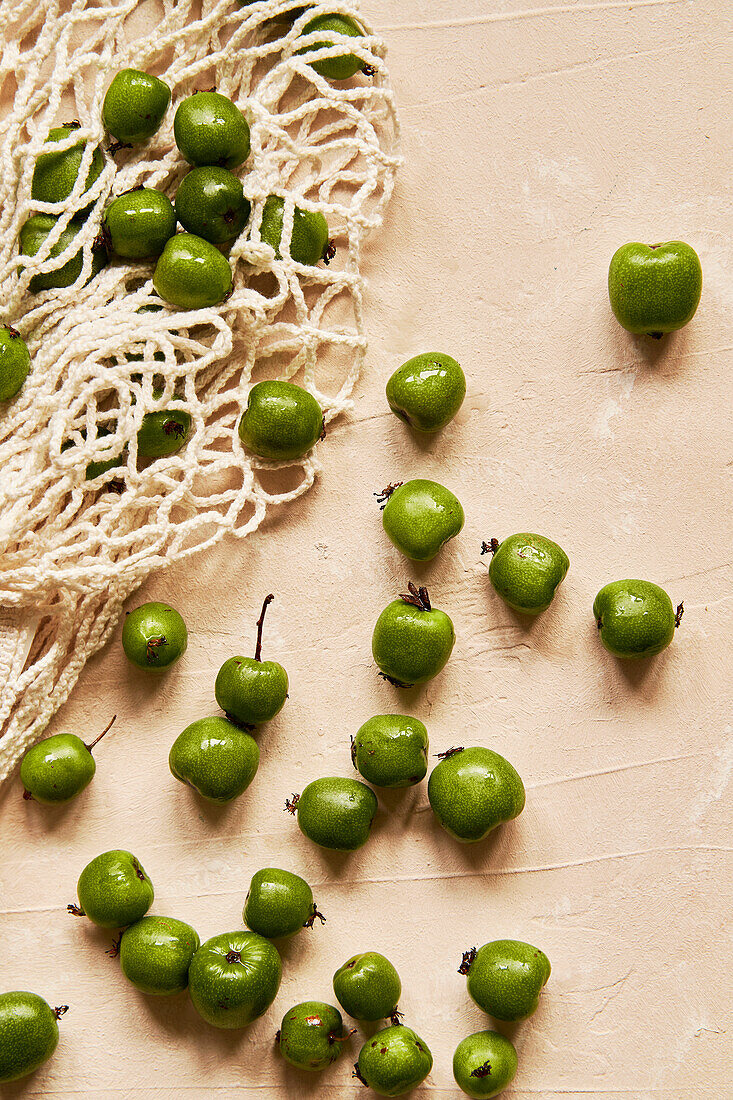 Kiwi berries on beige background with fabric bag