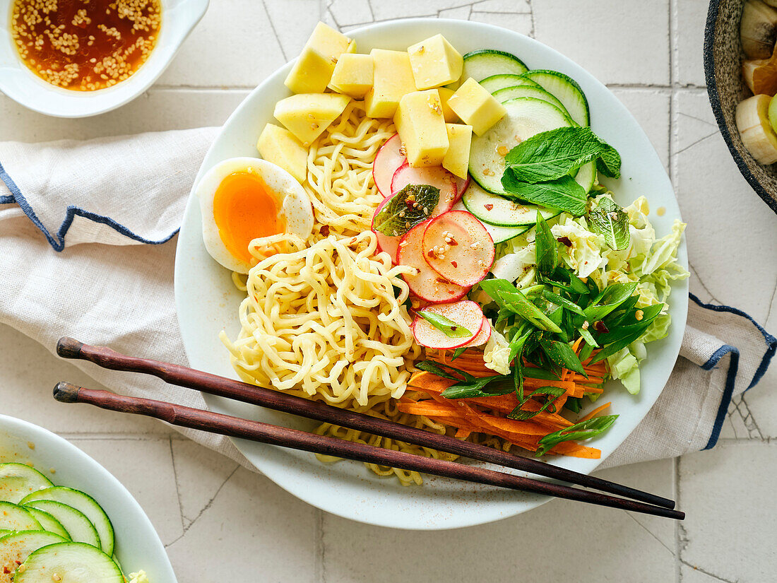 Salad Ramen - vegetarian dish with egg noodles, mango, lime and vegetables. Healthy pan-Asian cuisine