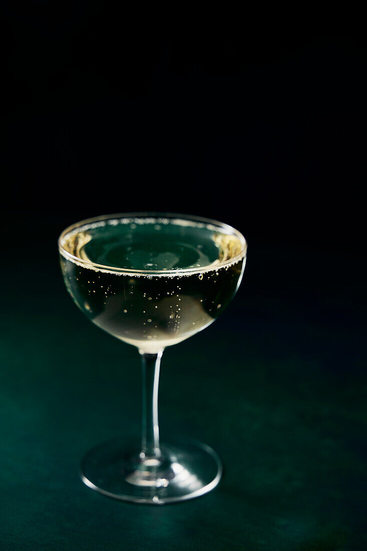 Prosecco glasses and golden plate on a green background