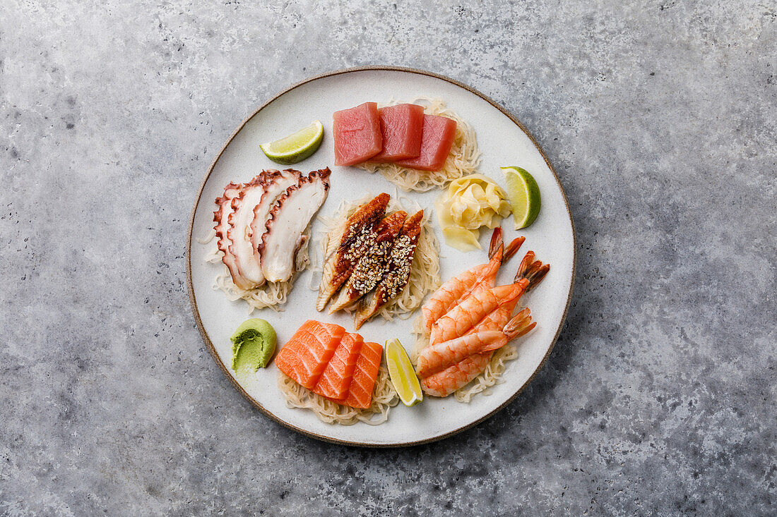 Sashimi-Sushi auf einem Teller vor grauem Hintergrund