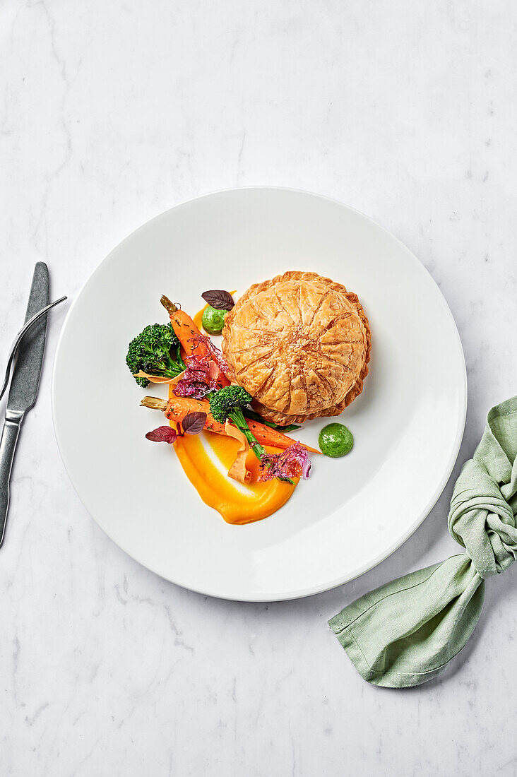 Blätterteigpithivier mit Karottenpüree, verkohlten Broccolini, Babymöhren und Salsa verde